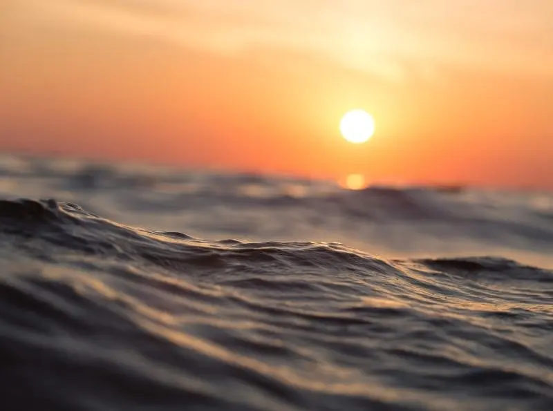 Meereswasser mit Sonnenaufgang am Horizont